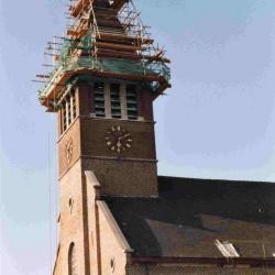 De torenspits van de kerk van Astene in de steigers