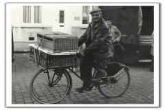 Pluimveehandelaar op de fiets met lading pluimvee